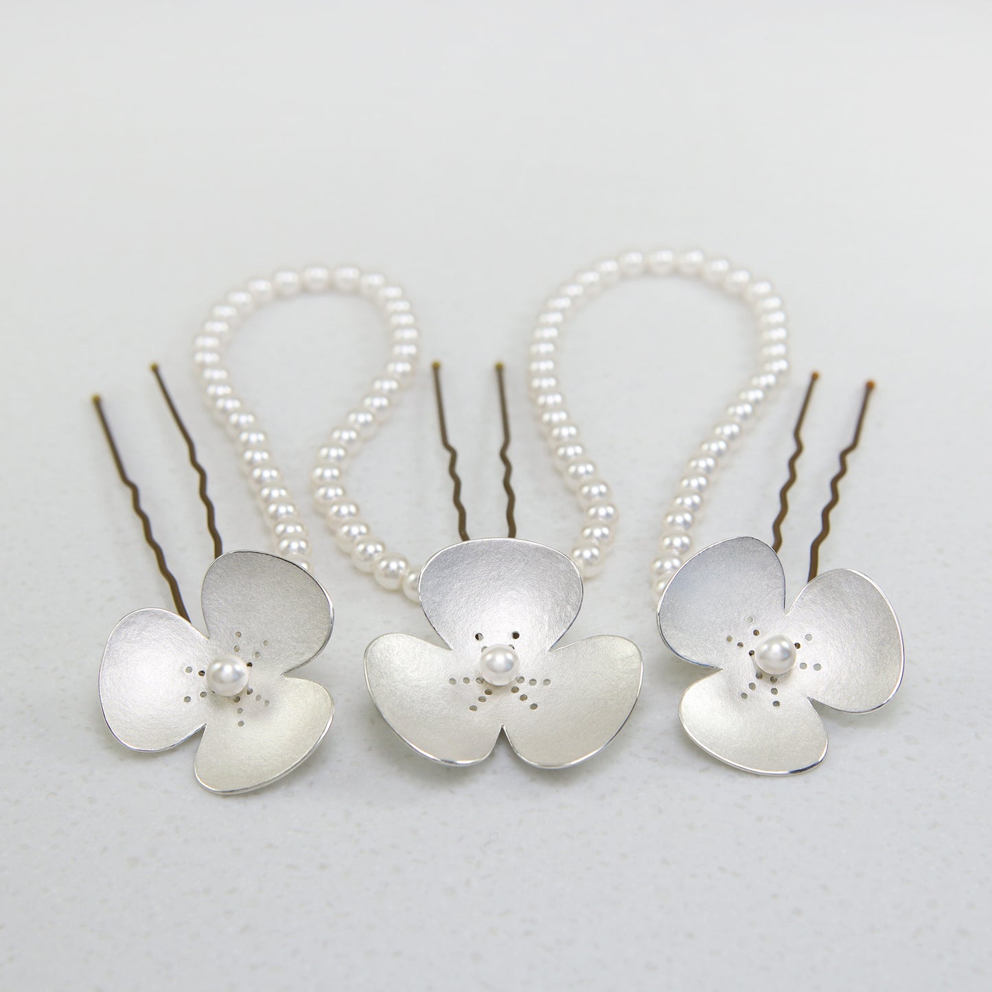 Three Silver and Pearl Poppy hairpins, which instantly convert to a set of jewellery